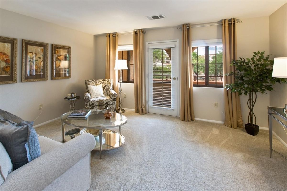A cozy living room with elegant furniture and large windows letting in natural light.