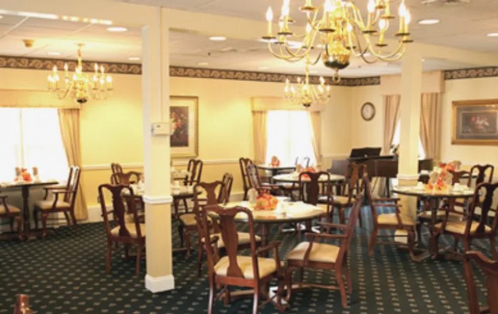A well-decorated dining room with elegant chandeliers and neatly arranged tables and chairs.