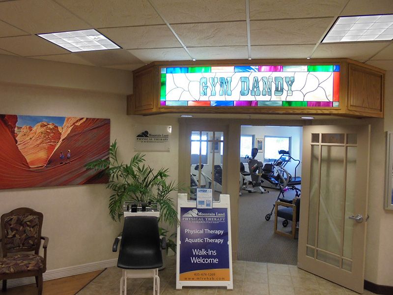Entrance to a fitness center with a bright sign and welcoming decor.