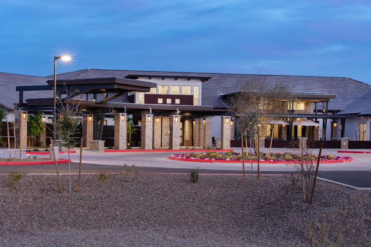 A modern building with a well-designed entrance, set against an evening sky.