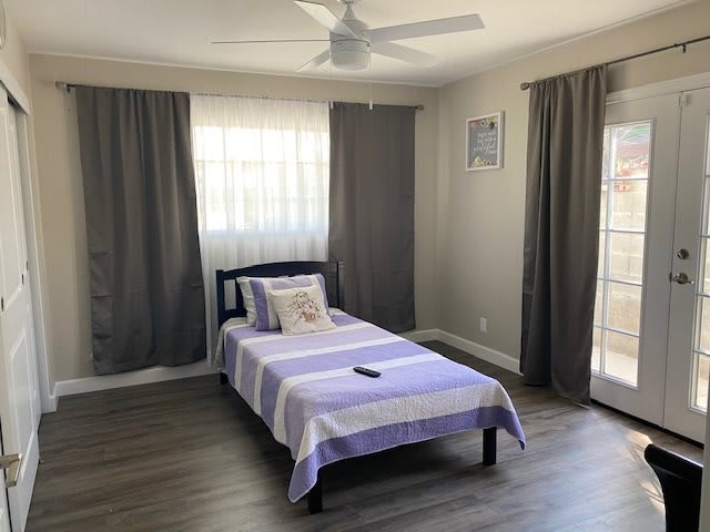 A minimalist bedroom with a single bed and gray curtains.