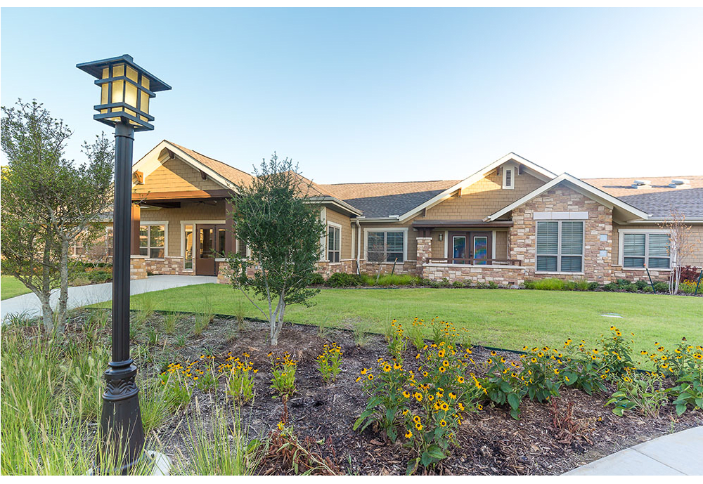 A beautiful house with well-maintained landscaping and a lush green lawn.