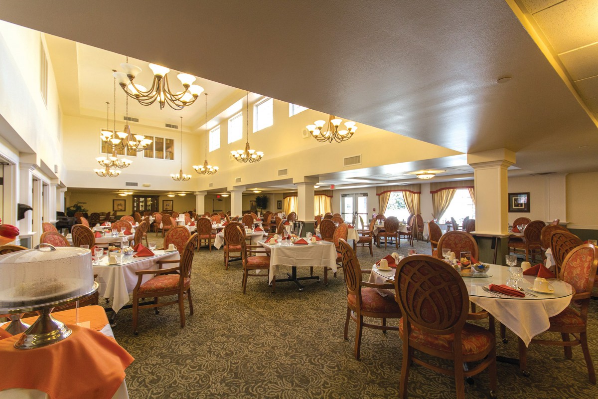 Spacious dining room with elegant lighting and table settings.