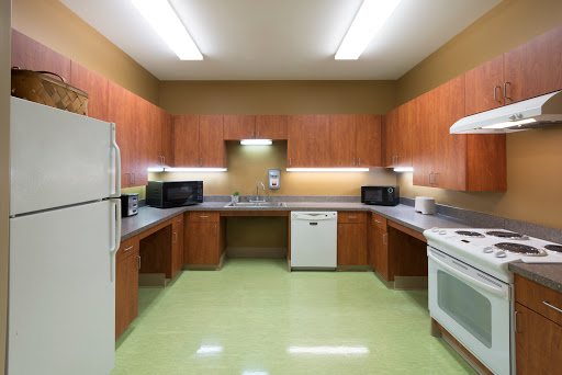 A modern kitchen featuring wooden cabinets and essential appliances.