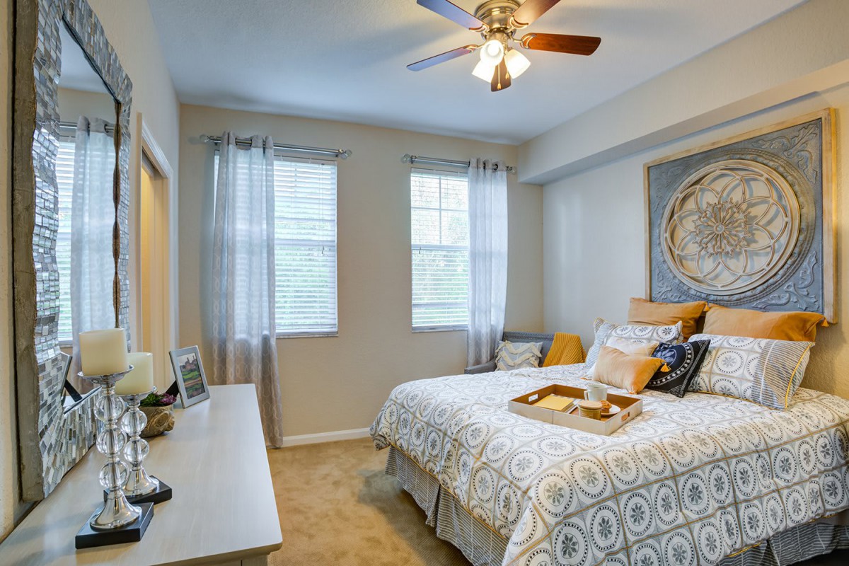 A cozy, well-lit bedroom with a neatly made bed and tasteful decor.