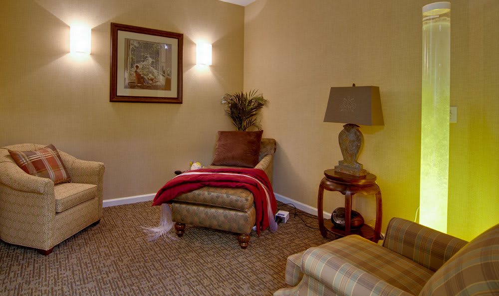 A cozy living room with an armchair, lamp, and side table.
