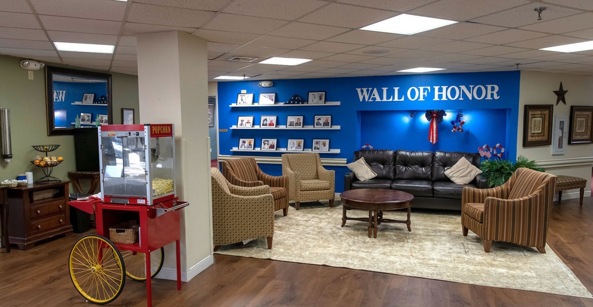 A cozy lounge area with comfortable seating and a 'Wall of Heroes' display.
