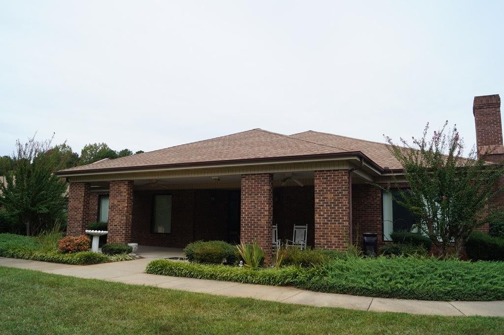 A single-story brick house with a garden in front.