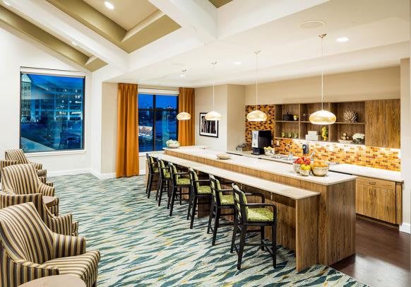 A modern kitchen and dining area with bar stools and stylish lighting.
