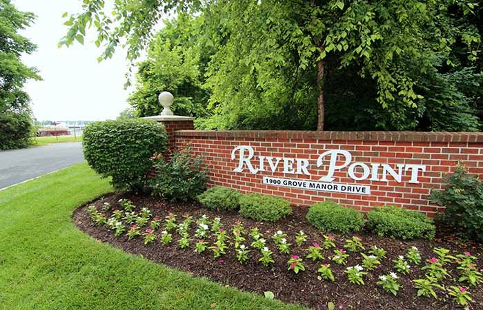 Entrance to River Pointe community with landscaped flowers and greenery.