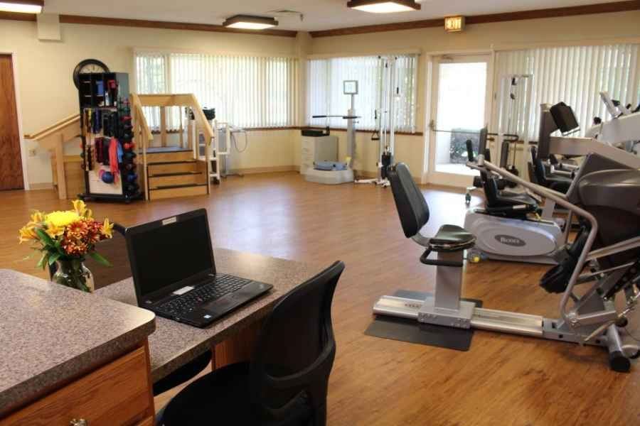 A spacious rehabilitation center equipped with exercise machines and therapy tools.