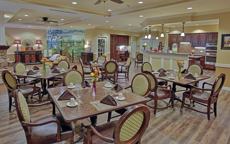 A cozy restaurant dining area with elegantly set tables, inviting decor, and warm lighting.