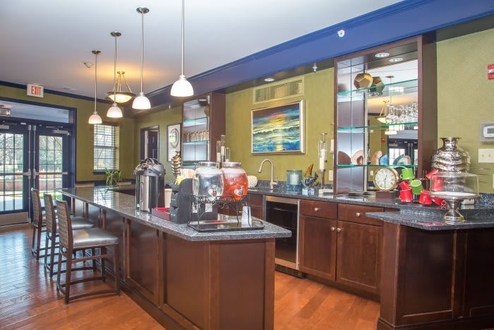 A modern kitchen with wooden cabinets and pendant lighting.