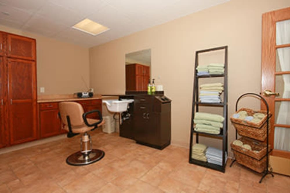A tidy salon interior with a styling chair, sink, and neatly arranged towels.