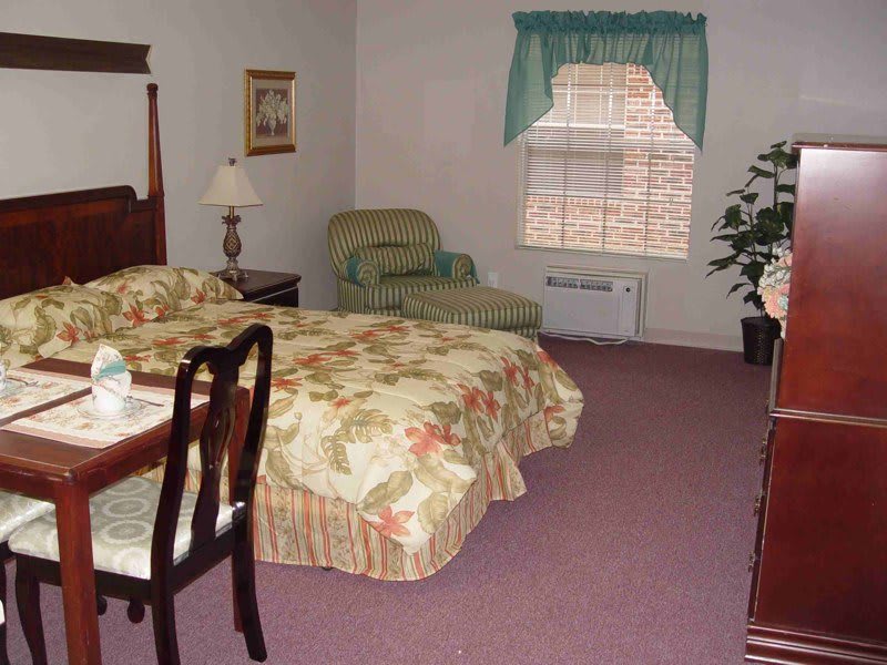 A cozy hotel room with floral decor and comfortable furnishings.