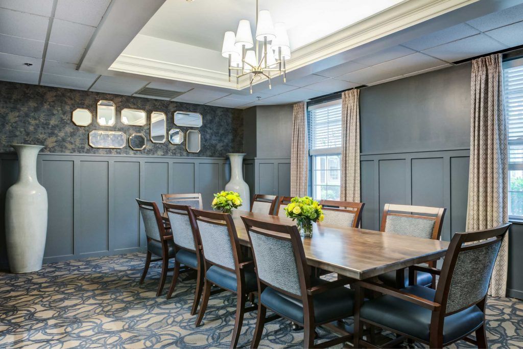 Elegant dining room with a large table, chairs, and decorative lighting.