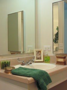 A neatly arranged bathroom sink area with a mirror and decorative items.
