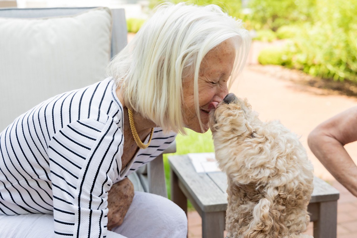 A woman shares a joyful moment with her dog in the park.