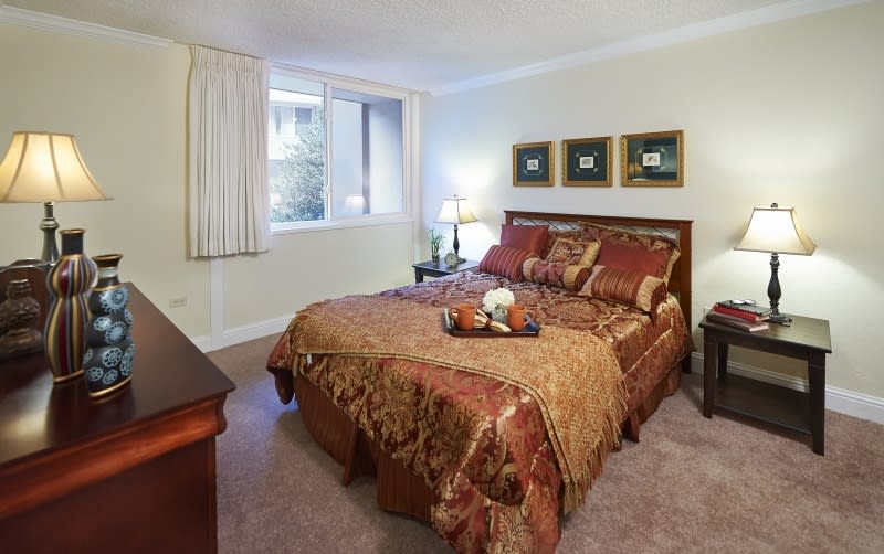 A cozy bedroom with elegant decor and warm lighting.