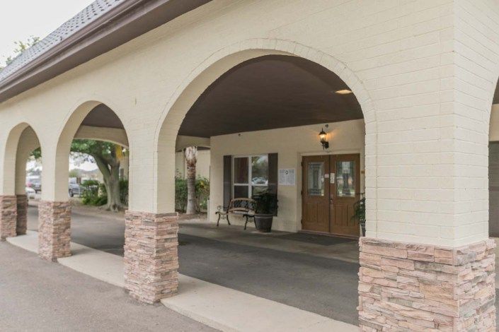 An exterior view of a building with an arched entrance and double doors.