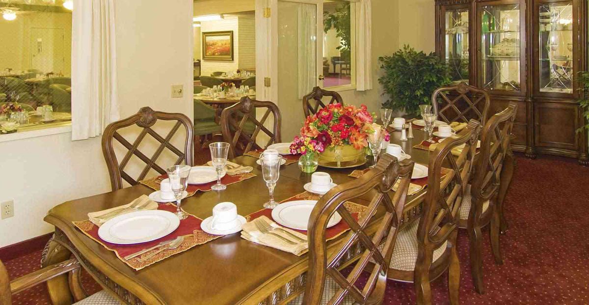 A beautifully set dining table with elegant plates, cups, and a floral centerpiece.