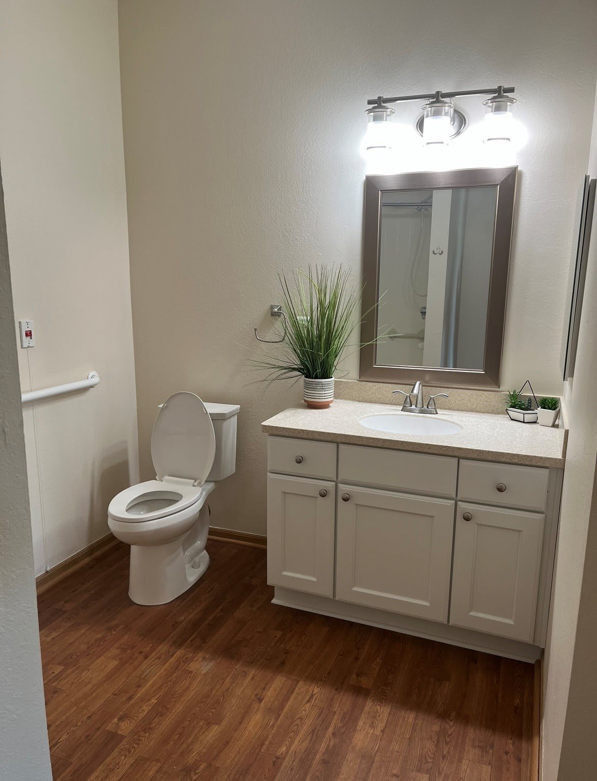 A clean and modern bathroom with a toilet, sink, and mirror.