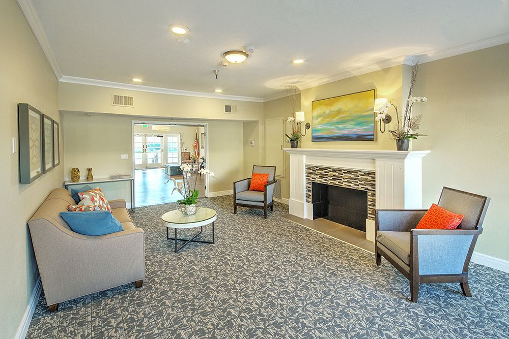 A cozy living room with comfortable seating and a decorative fireplace.