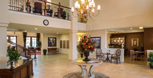 A beautifully designed hotel lobby featuring elegant decor, a large chandelier, and vibrant floral arrangements.
