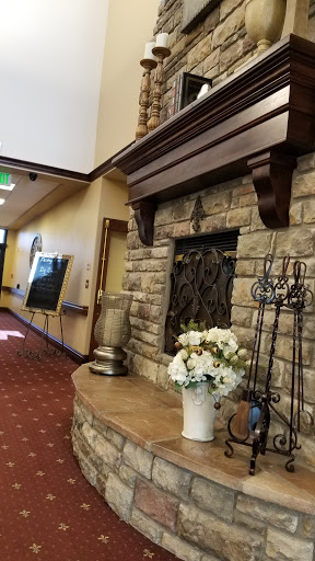 A welcoming lobby featuring a beautifully crafted stone fireplace and tasteful floral arrangements.