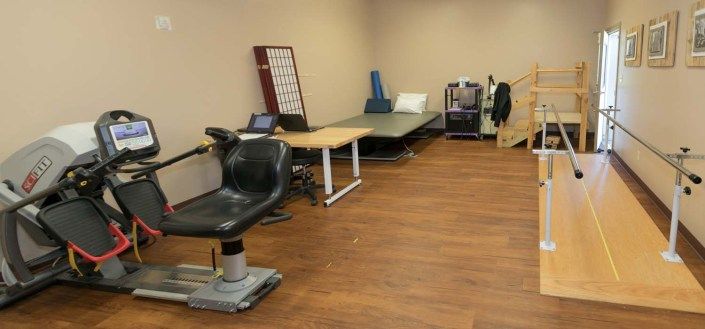 A therapy room with medical equipment and an exercise table.