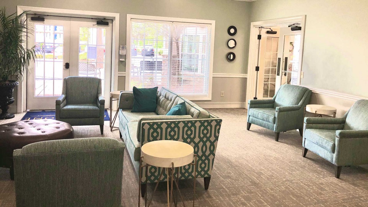 A cozy and modern living room with patterned sofas and large windows.
