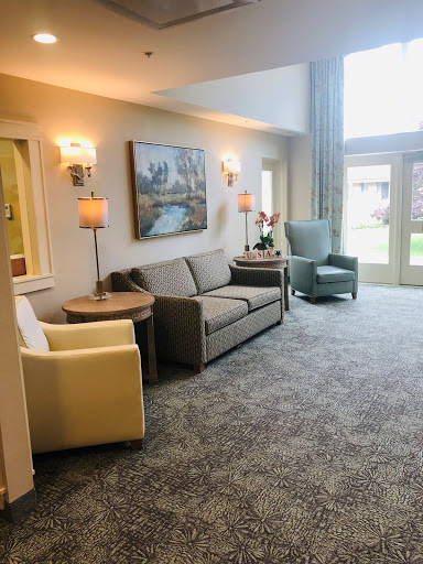 A cozy living room setting with comfortable furniture, soft lighting, and a view of the outdoors.