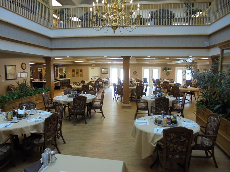 A spacious dining hall with elegantly arranged tables and a chandelier.