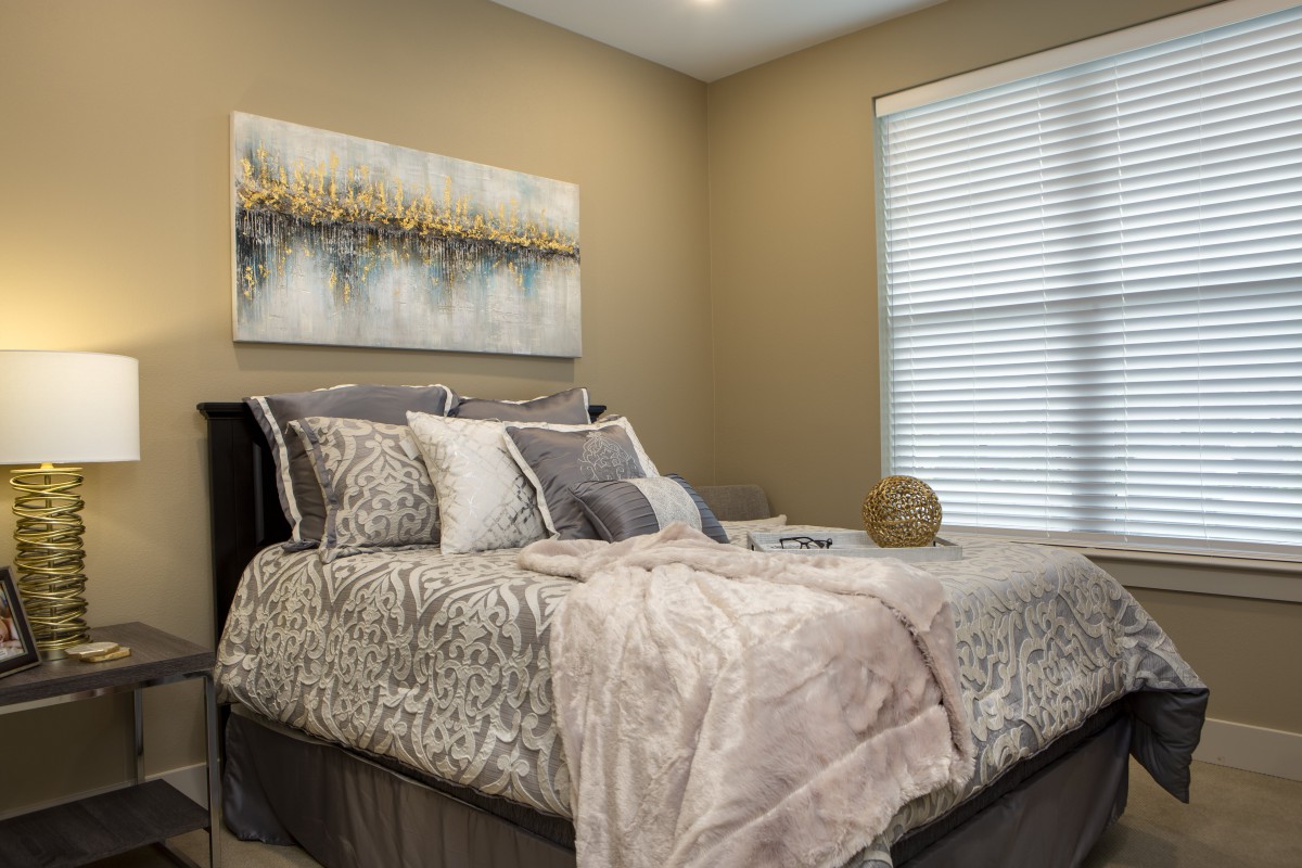 Cozy bedroom with stylish bedding and artwork on the wall.