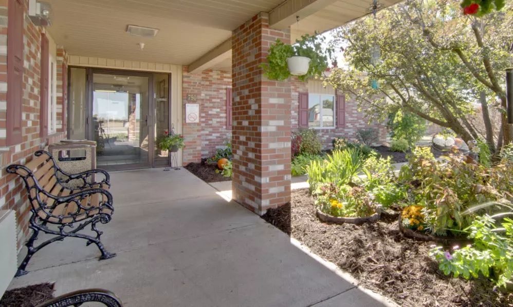 A welcoming building entrance with a landscaped garden and pathway.