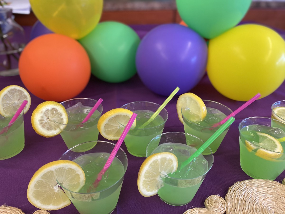 Colorful party setup with lemonade drinks and vibrant balloons.