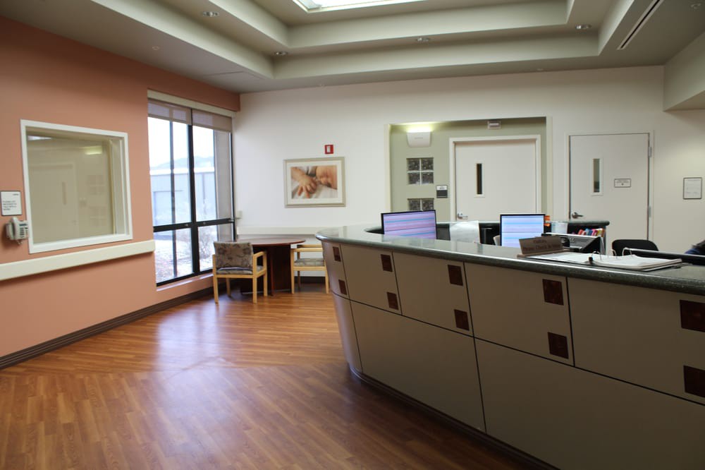 A hospital reception area with a desk, computers, and seating.