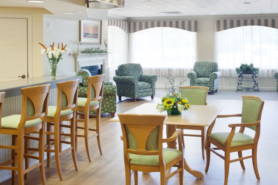 A cozy and bright living room area with comfortable armchairs, a table, and decorative elements.