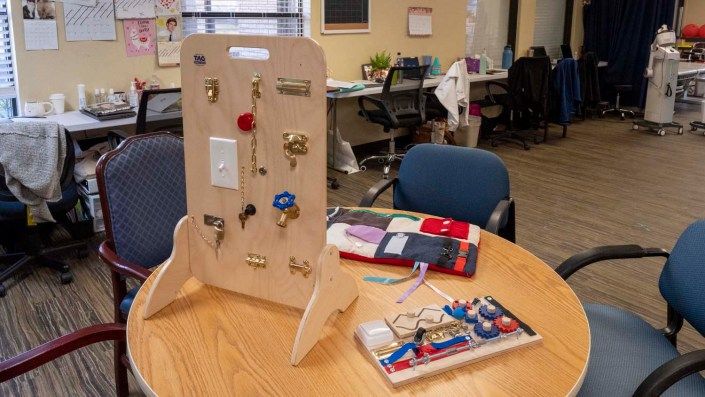 An office setting with various sensory boards used for occupational therapy and interactive learning.