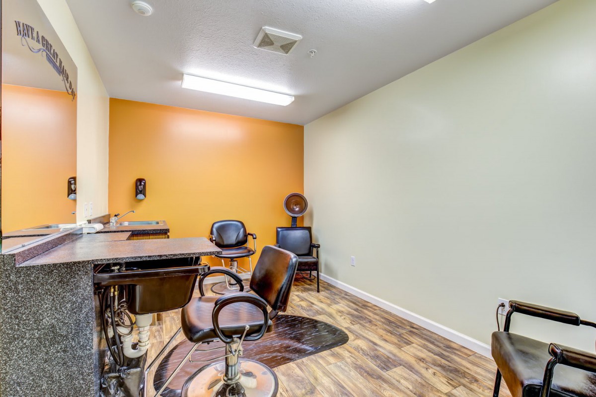 A well-lit hair salon with stylish chairs and mirrors, featuring vibrant wall colors.