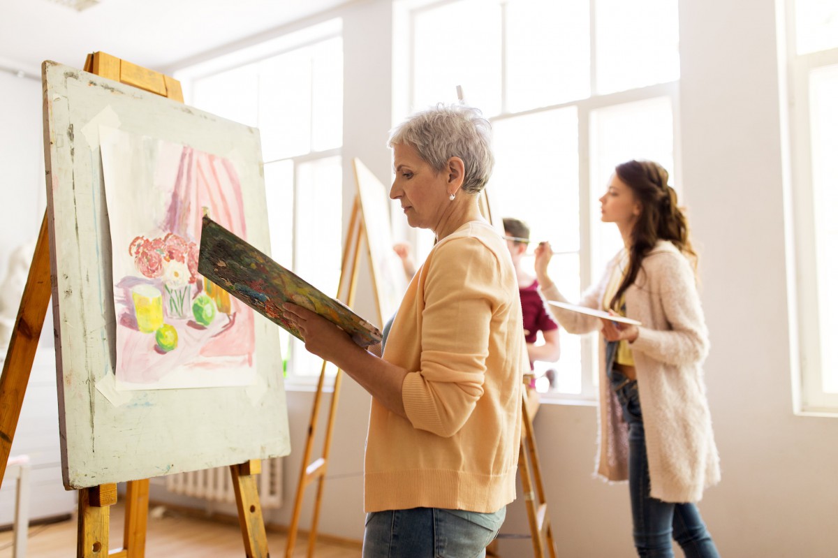 Artists engaged in a painting class, working on their canvases with focus and creativity.