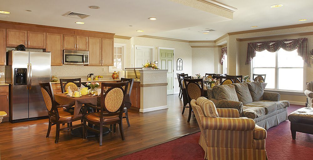 Open concept living and dining area with a kitchen in the background.