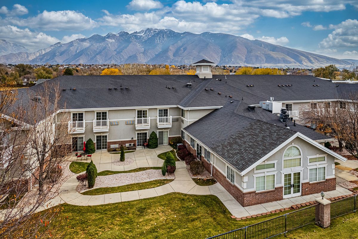 A residential building with a mountain backdrop and clear sky.