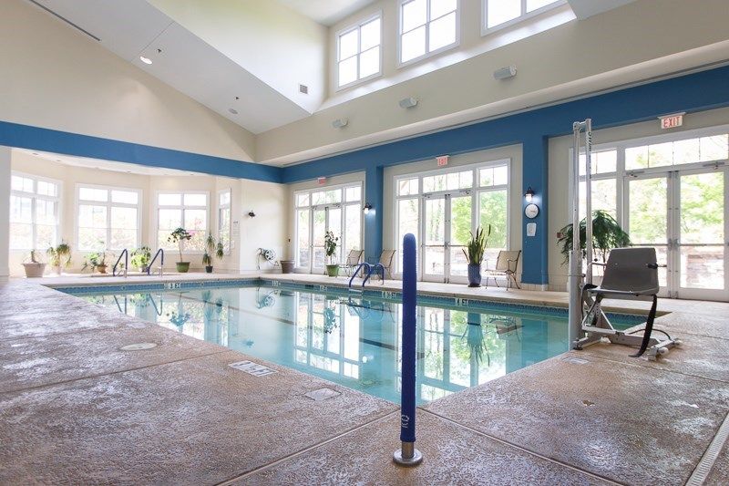 An inviting indoor swimming pool with large windows allowing natural light to brighten the area.