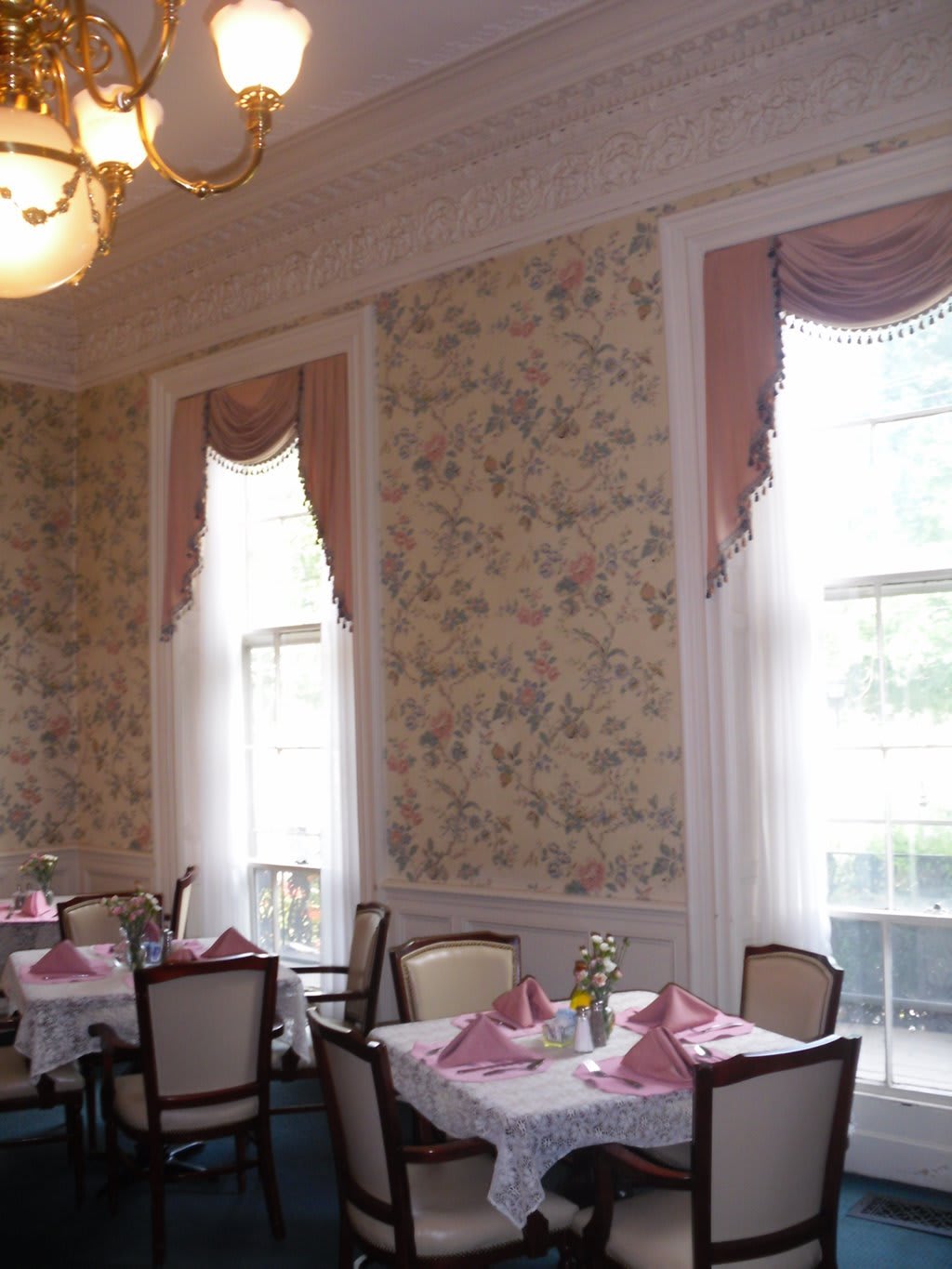 An elegant dining room with classic decor and neatly set tables.