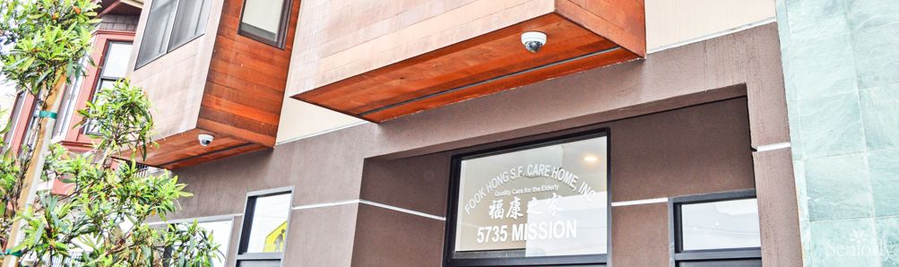 A storefront with a security camera and window displaying the address 5735 Mission.