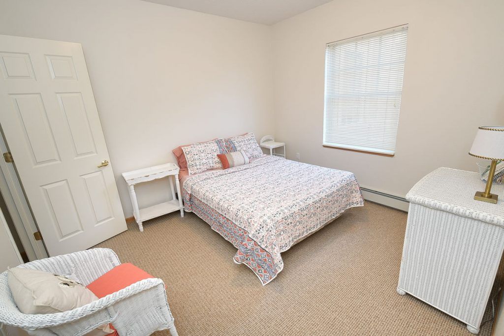 A simple bedroom with a double bed, two nightstands, and a window.