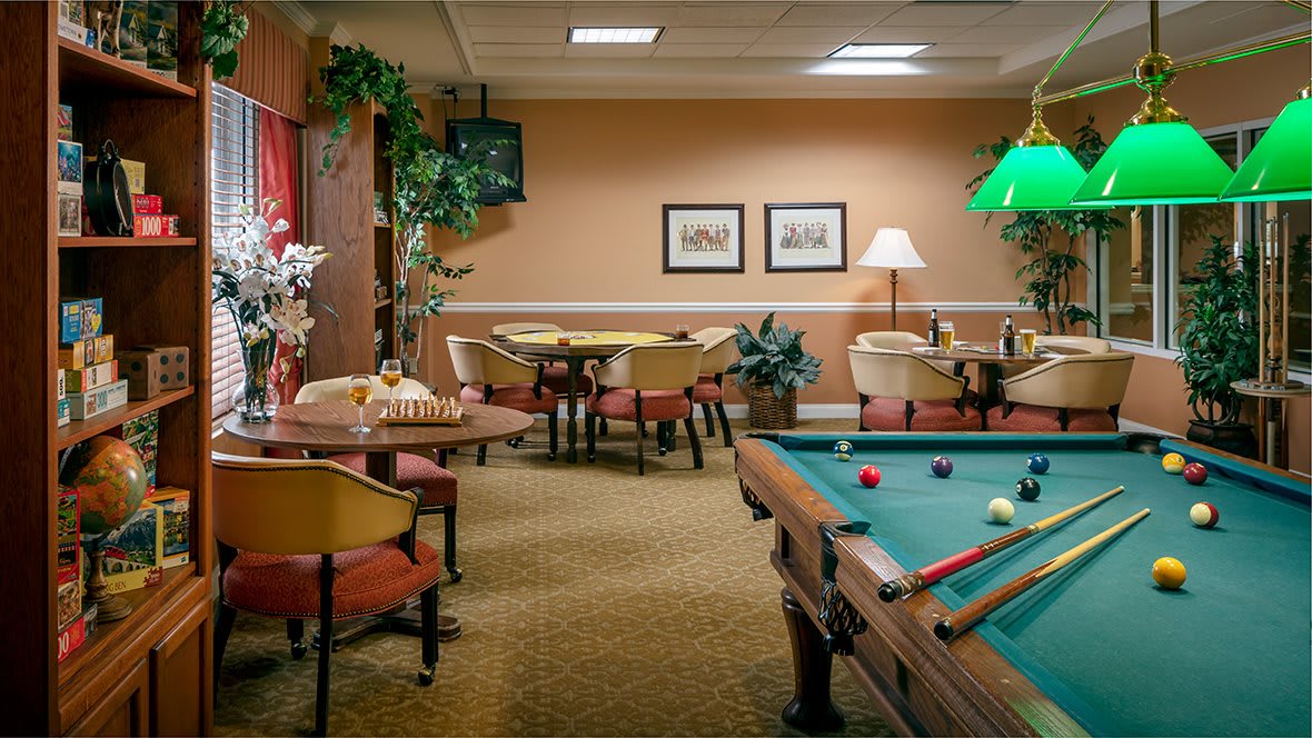 A cozy game room with a pool table and seating area.