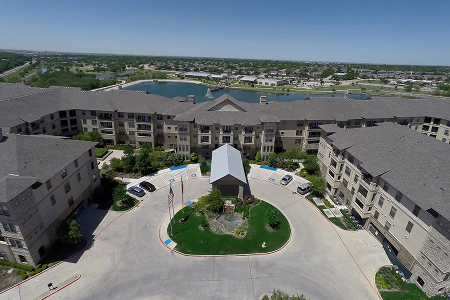Aerial view of a residential apartment complex with a nearby lake.