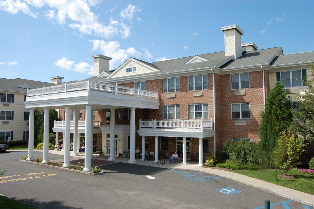 A modern senior living facility with a welcoming entrance and classic architectural design.